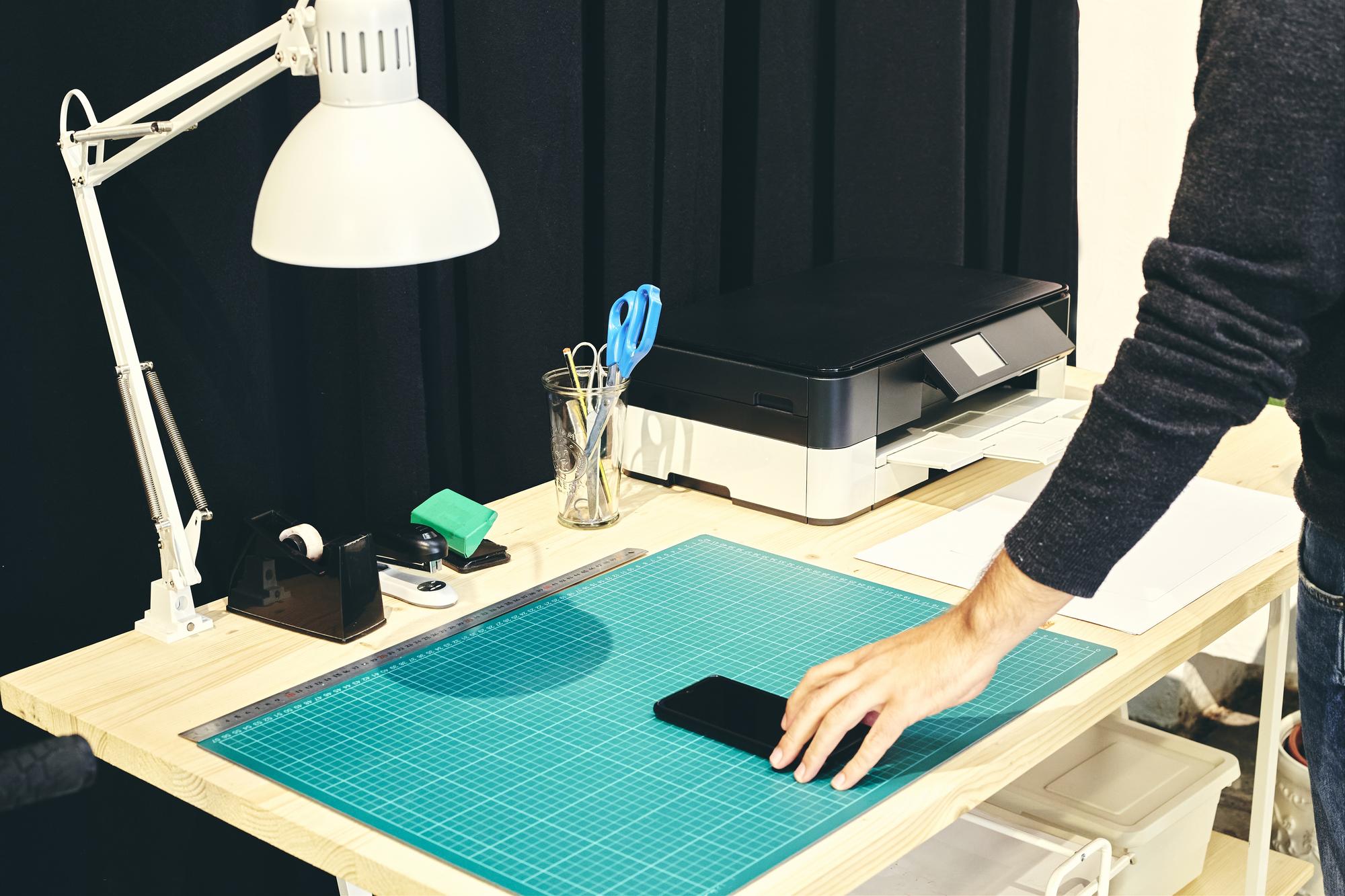 Studio desk with samples and a compact embroidery machine