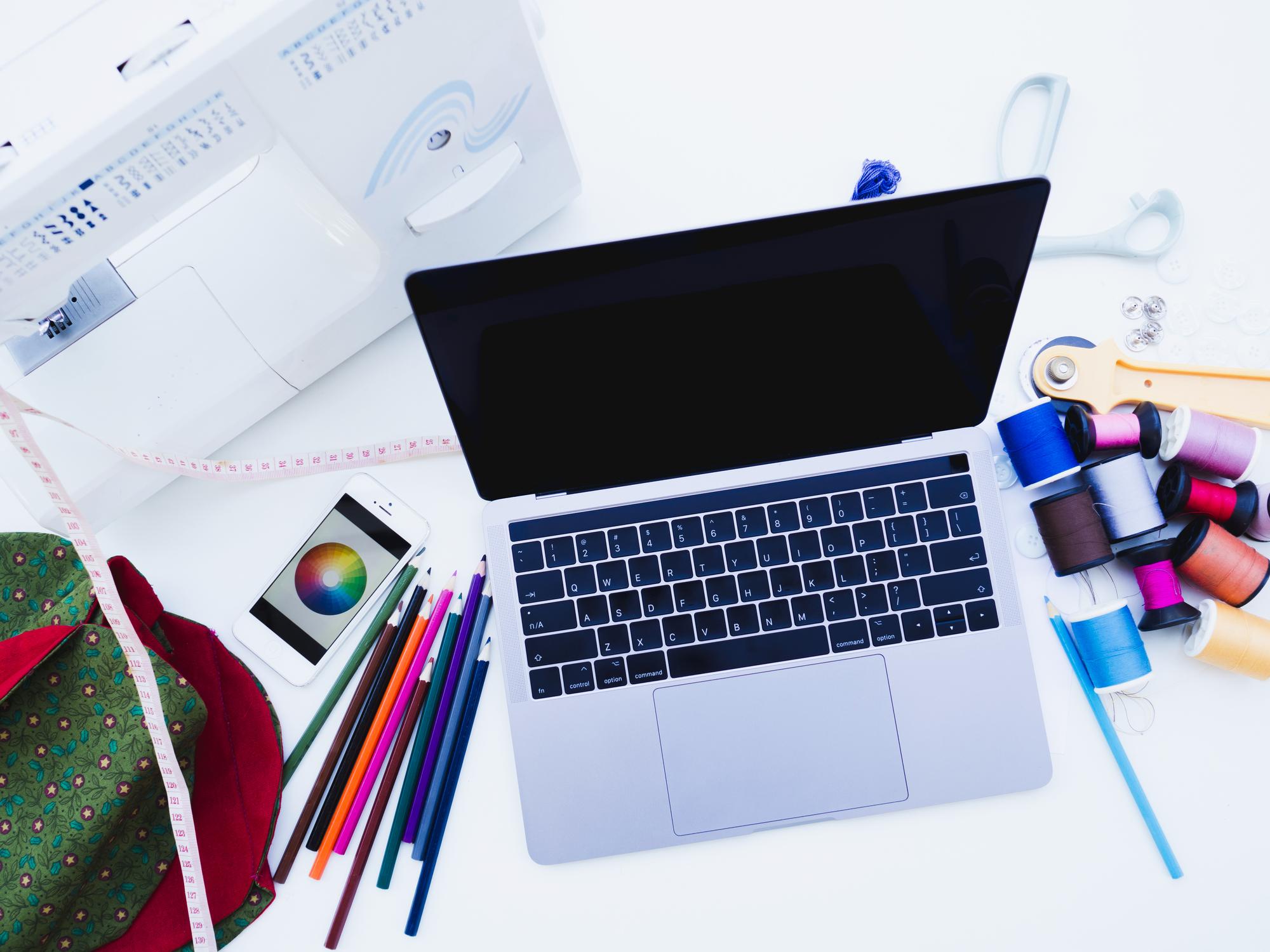 Laptop with embroidery design on screen, modern studio